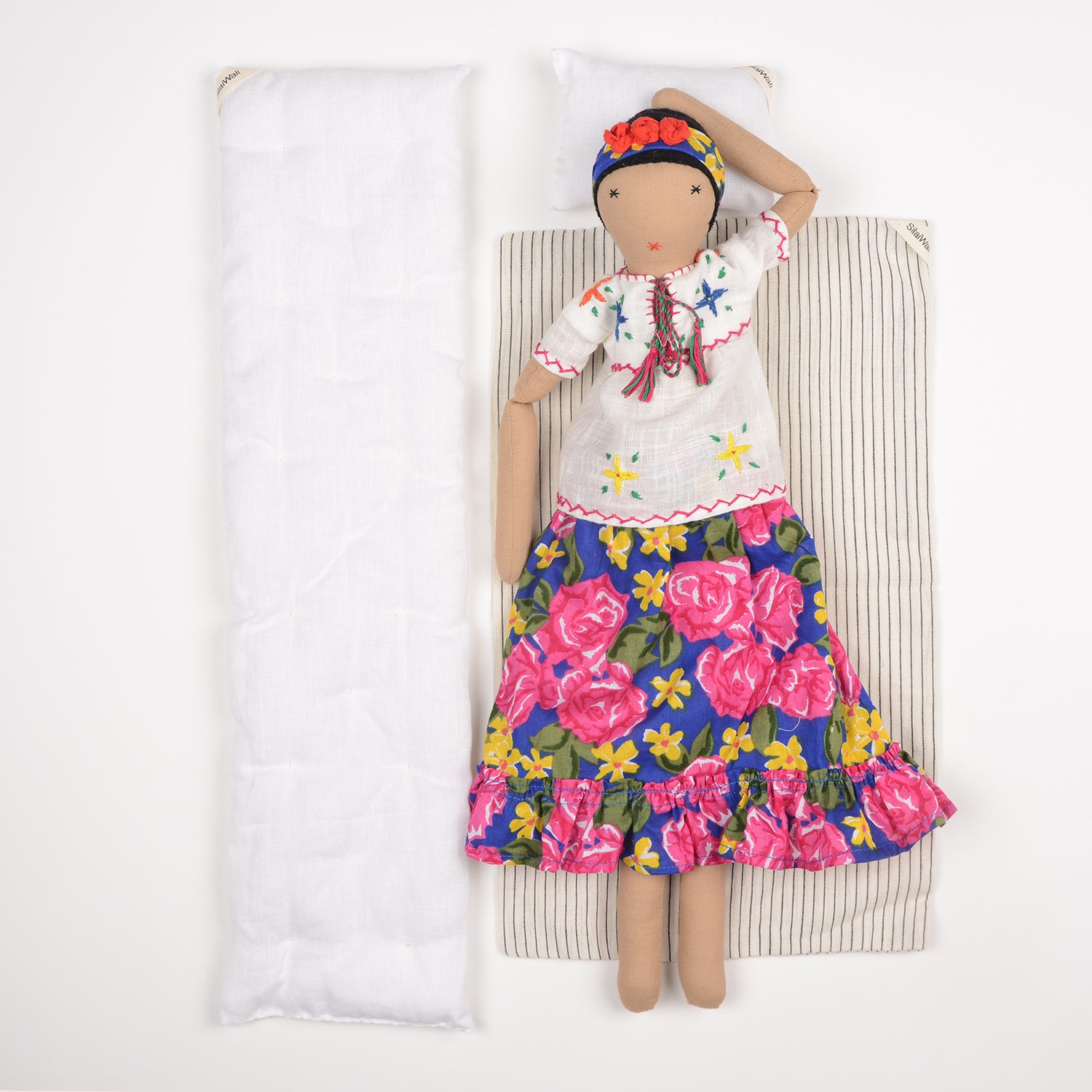 Frida, a handcrafted Afghan doll with vibrant floral patterns and intricate embroidery, symbolizing resilience and empowerment.